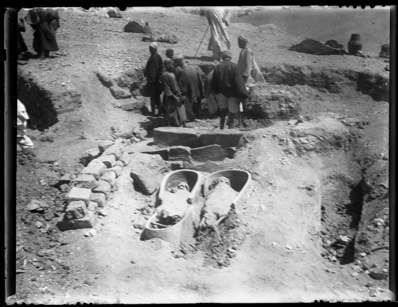  Discovery of two terracotta coffins containing the skeletal remains of two human bodies during excavations at Qau el-Kebir. In the background, workmen engaged in activity. Schiaparelli excavations.