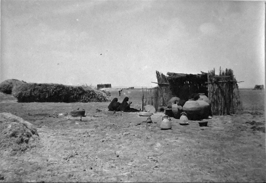 Paesaggio nell’area di Qau el-Kebir e ritratto di scena di vita quotidiana, in prossimità della necropoli rupestre. Due donne sono fotografate mentre si riposano. Archivio Angelo Sesana. 