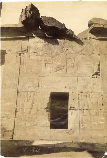 The photograph shows scenes from the back wall of the second hypostyle hall of the Temple of Seti I at Abydos, where the pharaoh can be seen in the presence of the gods Ptah and Horus. The author's signature is visible at the lower left. 