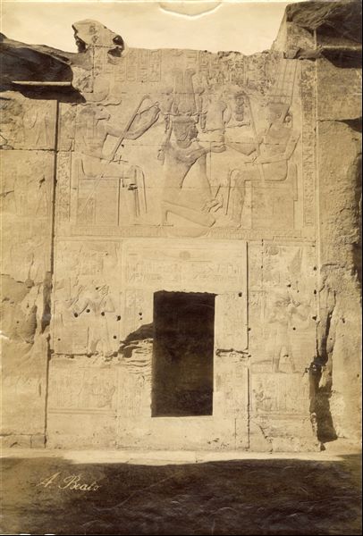 The photograph captures a scene from the back wall of the second hypostyle hall of the Temple of Seti I at Abydos. The author's signature is visible at the lower left.   