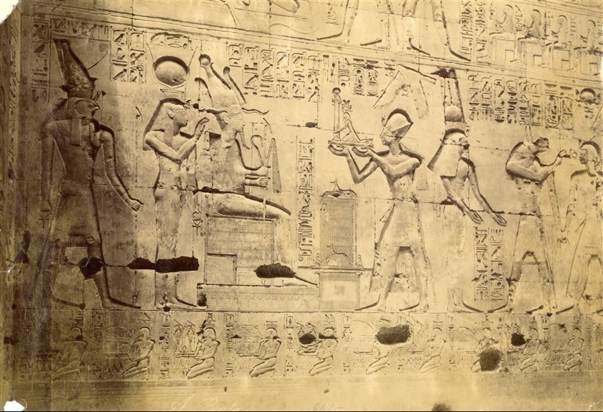 The photograph shows wall scenes carved in relief on the first hypostyle hall of the Temple of Seti I at Abydos, decorated by Ramesses II. The pharaoh is depicted bringing offerings to Osiris. The author's signature is at the bottom.   